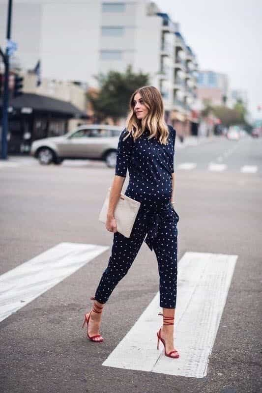 Moda para gestante vestida com macacão de poá e sandália vermelha