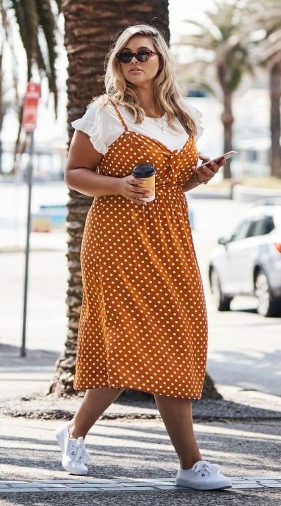 Look plus size com vestido de bolinha e camiseta branca de sobreposição