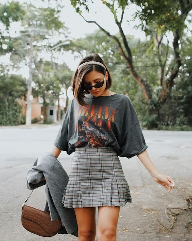 Look com camiseta de banda e mini saia estilo colegial 