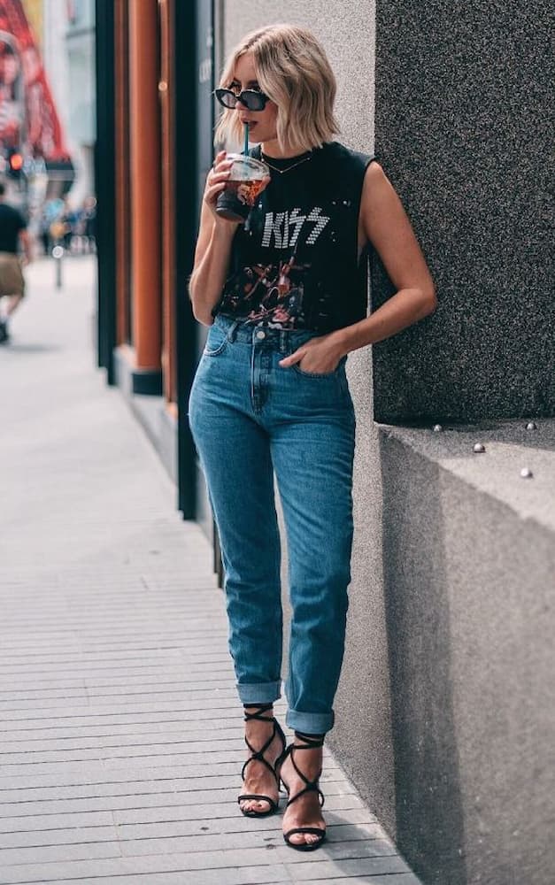 calça jeans para look com camiseta de banda regata e sandália de salto 