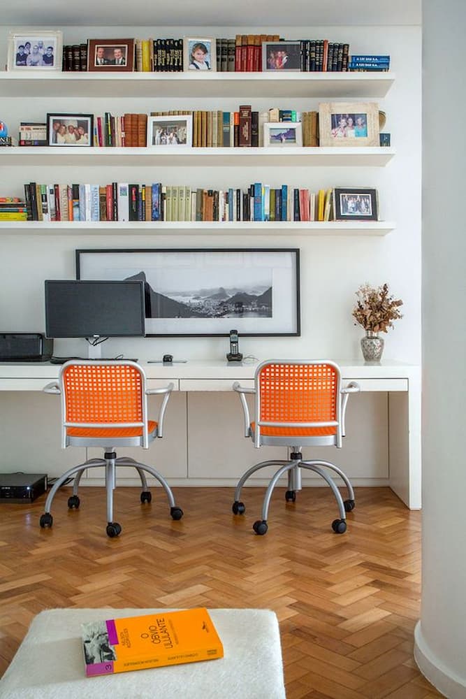 Prateleiras para decoração de home office com cadeiras laranja 