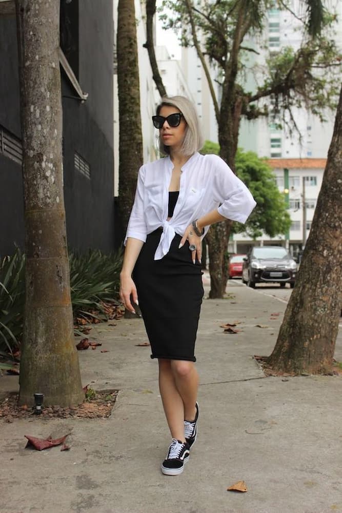 Ideia de look com camisa branca amarrada e vestido preto 