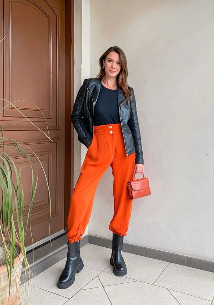 jaqueta de couro para look com calça laranja e bota