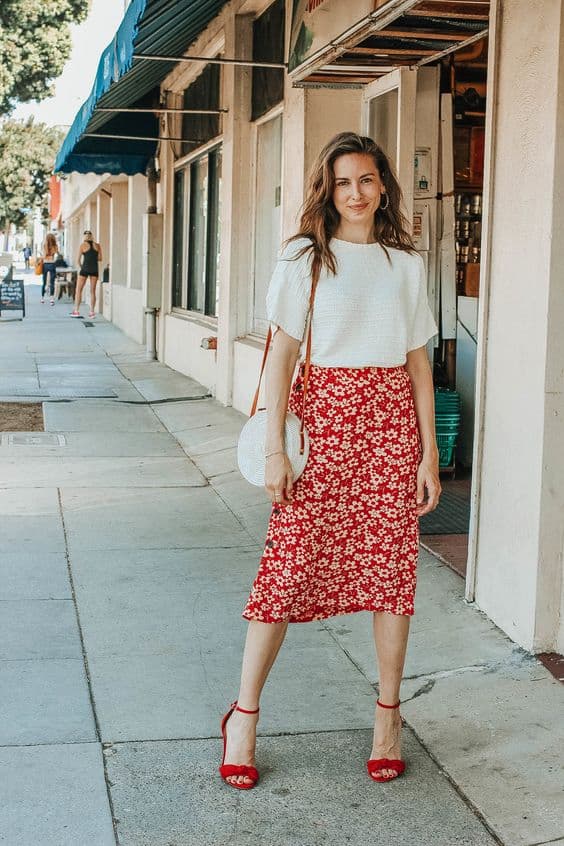 sandália vermelha para look com camisesta branca e saia estampada 