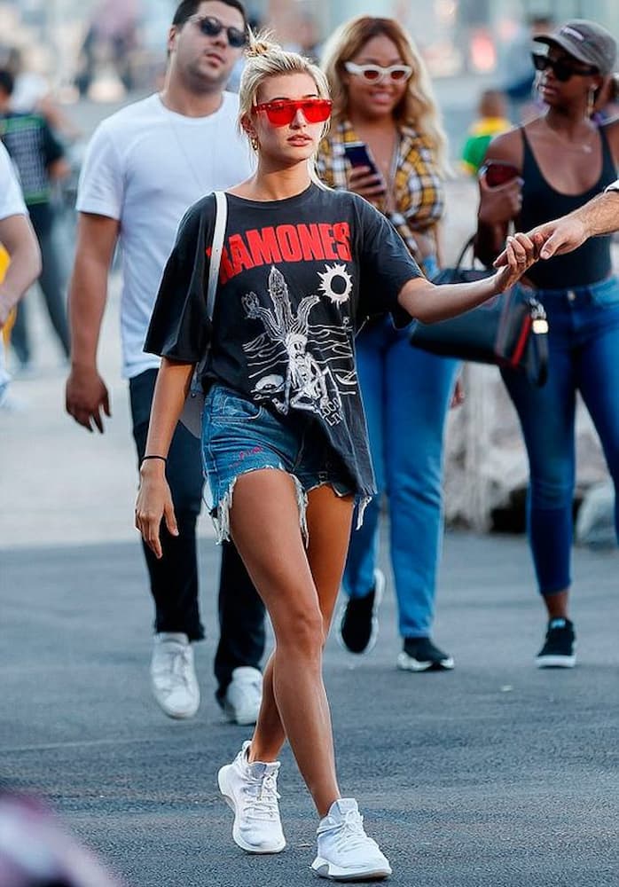 tênis branco para look com camiseta de banda e shorts jeans 