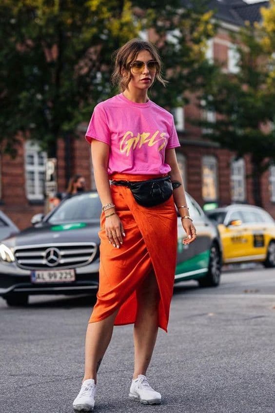 tênis branco para look com camiseta rosa e saia laranja 