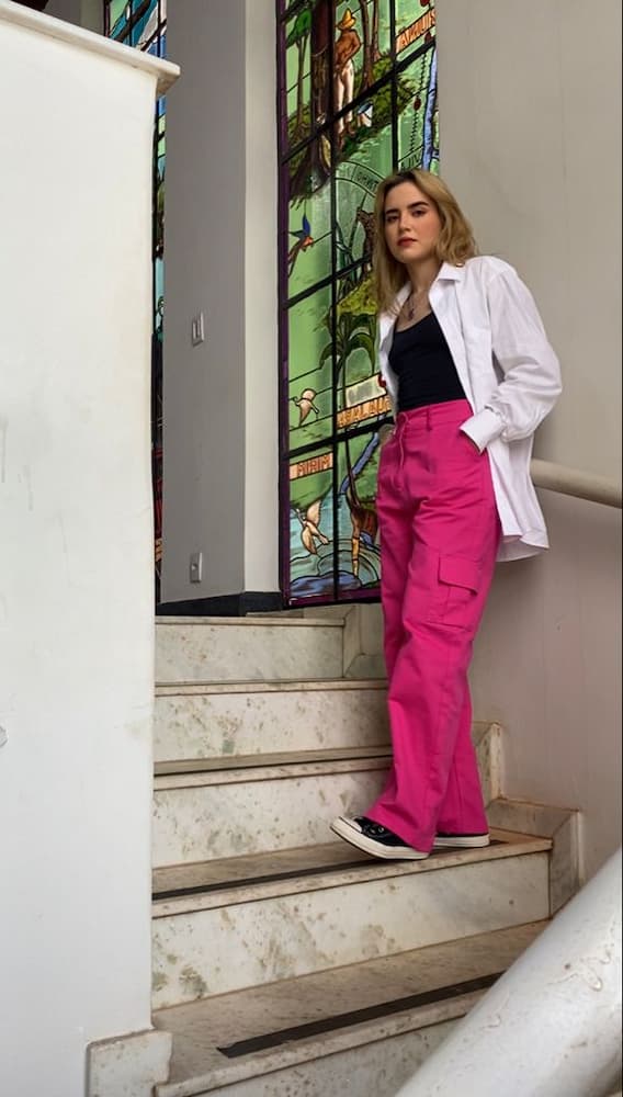 camisa branca aberta para look com calça rosa e tênis