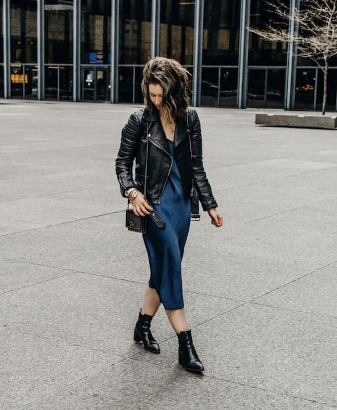 look slip dress azul com bota cano baixo e jaqueta de couro