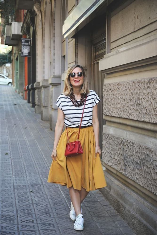 camiseta listrada para look com tênis branco e saia amarela