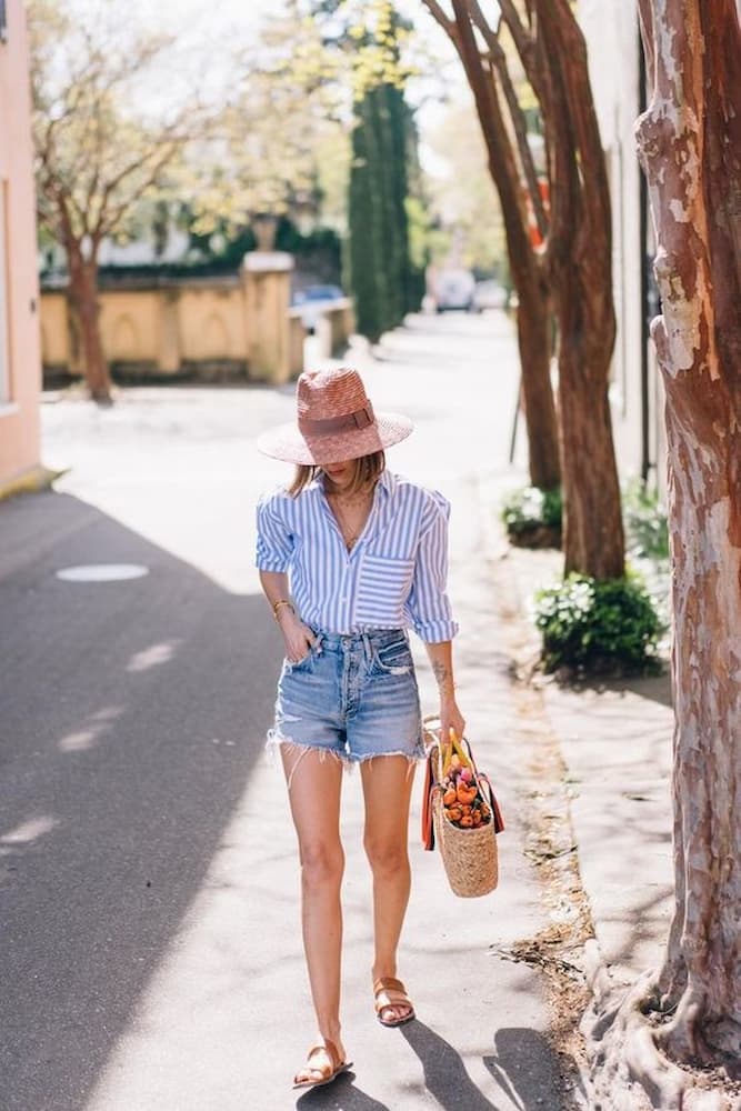 chapéu de palha para look com camisa listrada e shorts jeans