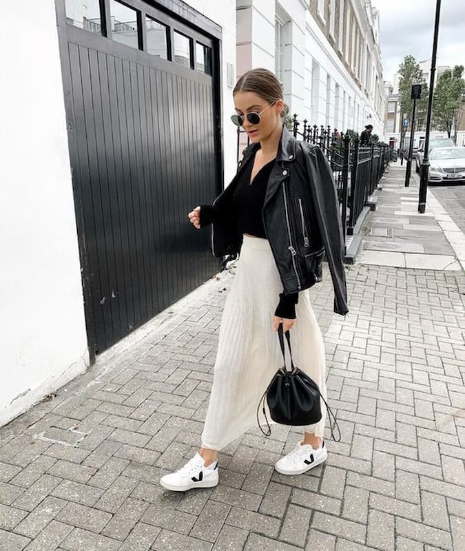 saia plissada para look com tênis branco e jaqueta de couro