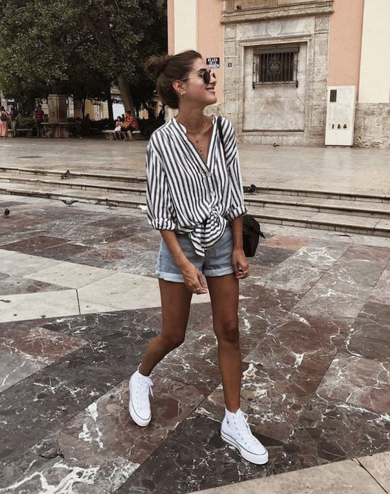 tênis branco para look com camisa listrada e shorts jeans 