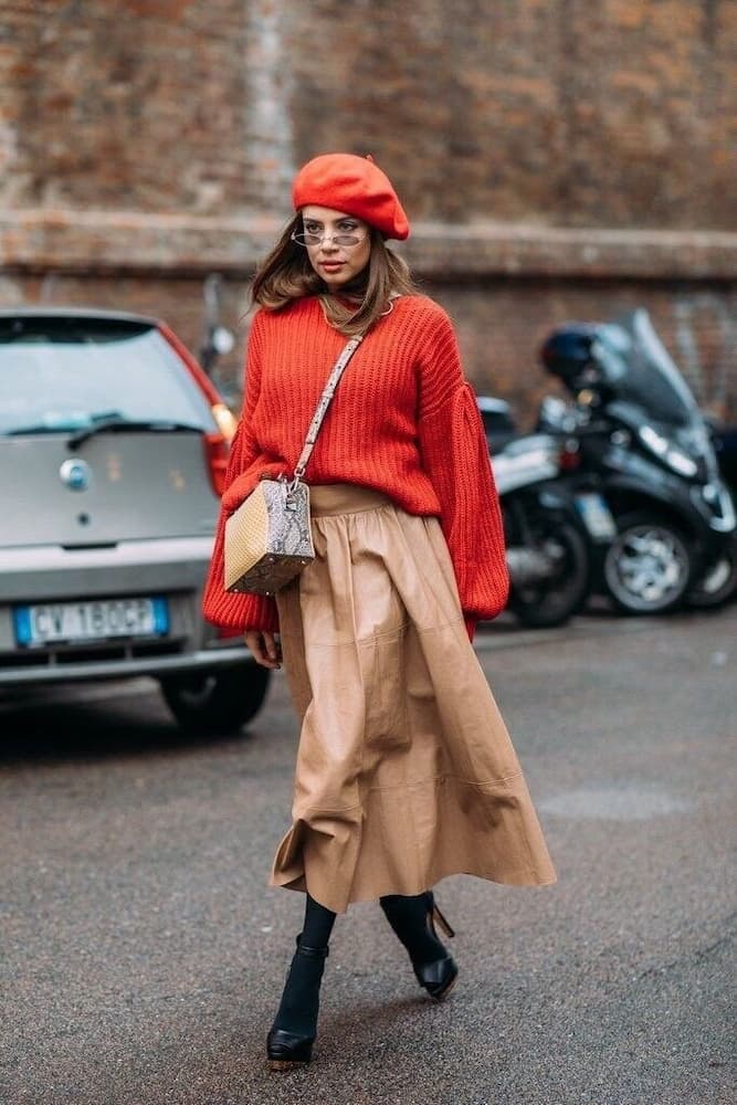 blusa laranja para look de inverno com saia midi de couro