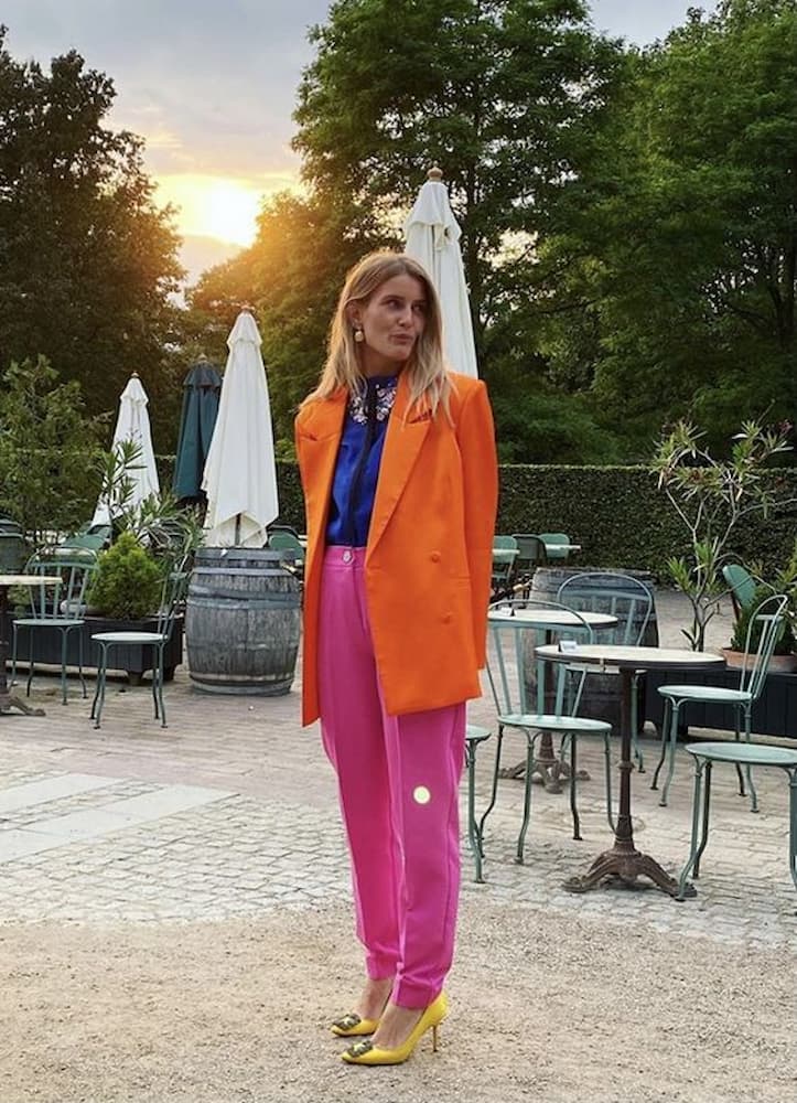 calça rosa para look colorido com blazer laranja e camisa azul 