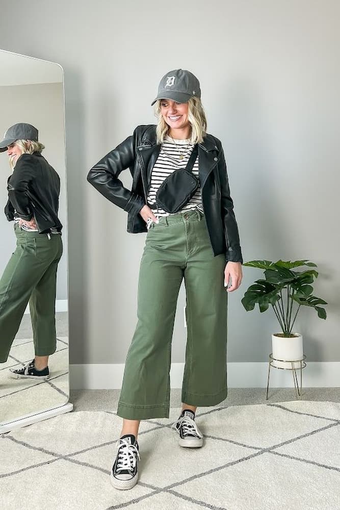 jaqueta de couro para look com calça verde miligar e camiseta listrada 