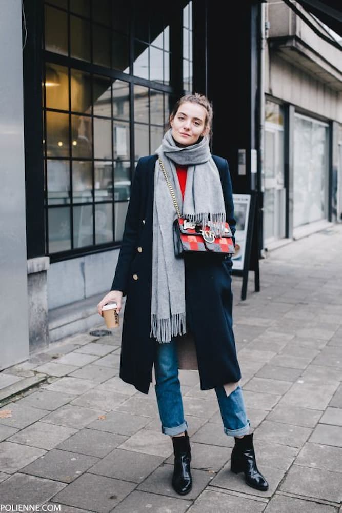 bota preta e calça jeans para look com cachecol e sobretudo 