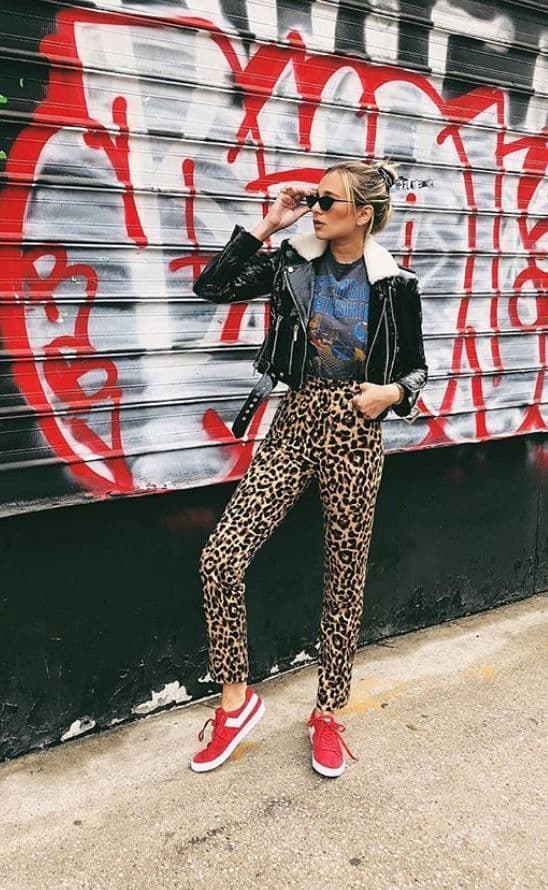 tênis vermelho para look com calça animal print e jaqueta de couro